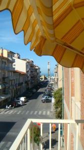 a view of a street from a balcony with an umbrella at Hotel I 4 Assi in Viareggio