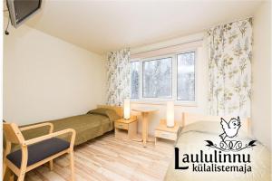 Laululinnu Guesthouse في Järvajõe: غرفة نوم صغيرة بها سرير ونافذة