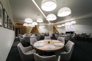 a conference room with tables and chairs and lights at Hotel Bank in Kiseljak