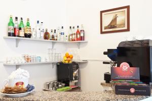 a bar with a counter with drinks on shelves at Hotel I 4 Assi in Viareggio