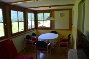 a dining room with a table and chairs and windows at Pension Edelweiss Top21 in Gosau
