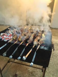 a grill with a bunch of meat on it at Guest house Romanadze in Kobuleti