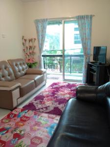 a living room with a couch and a television at Cameron Highlands Muslim Apartment by AziziCameron in Cameron Highlands