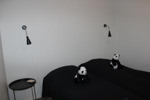 ケミにあるKototuuli Majoitusの二匹のパンダが部屋のベッドに座っている