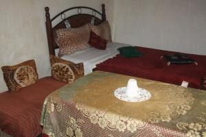 a bedroom with a bed and a table with a candle on it at Riad Elkorchi in Fez