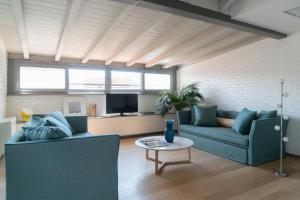 a living room with two blue couches and a table at Brera Apartments in San Fermo in Milan