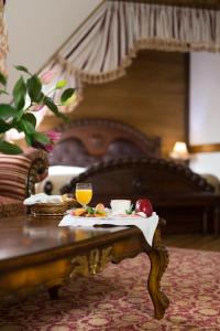 a table with a tray of food on top of a bed at Zámek Lužec Spa & Wellness Resort in Karlovy Vary