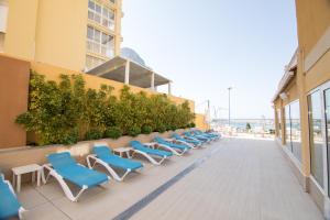 a row of chairs on a building with the ocean in the background at Hotel Porto Calpe in Calpe