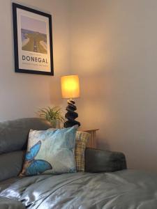 a living room with a couch and a lamp at Village Way Apartments in Kincasslagh