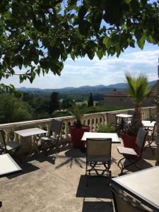 a patio with tables and chairs and a view at La Bastide Des Senteurs in Saint-Victor-de-Malcap