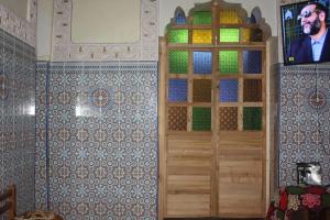 a room with a wooden door and a tv on a wall at Riad Elkorchi in Fez