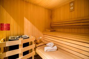 - un sauna avec une serviette assise sur un banc en bois dans l'établissement Hotel Les Bulles De Paris, à Paris