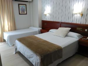マリンにあるHotel Villa de Marinのホテルルーム ベッド2台&ランプ2つ付