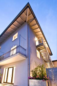 a white building with a balcony on the side of it at Manzoni 124 Bed&Relax in Esine