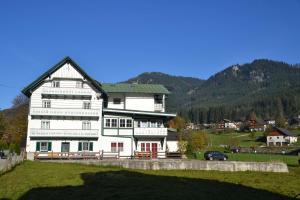 Casa blanca grande con techo verde en Pension Edelweiss Top21, en Gosau