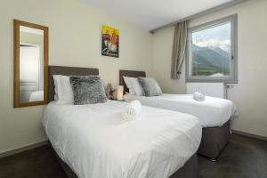 two beds in a room with a window at Apartment Aiglons in Chamonix