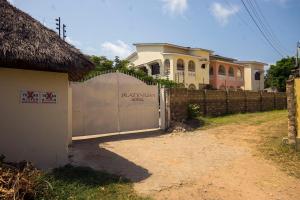 a fence with a gate in front of a house at Platinum Hotels Mombasa in Shanzu