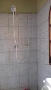 a shower in a bathroom with white tile walls at Platinum Hotels Mombasa in Shanzu +44 photos