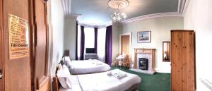 a hotel room with two beds and a fireplace at Cruachan Guest House in Edinburgh