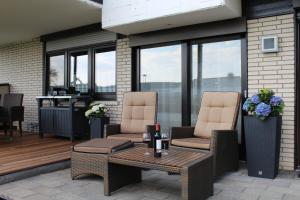 eine Terrasse mit 2 Stühlen und einem Tisch in der Unterkunft Ferienwohnung "Am Fischteich" in Möhnesee