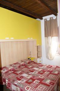 a bedroom with a bed and a yellow wall at Villa Miriam in Monte Nai