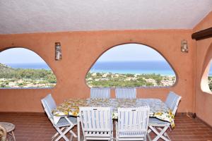 un tavolo e sedie su un balcone con vista sull'oceano di Villa Miriam a Monte Nai