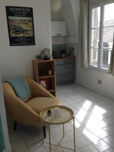 オンフルールにあるLe petit studio honfleuraisのリビングルーム(椅子、テーブル付)