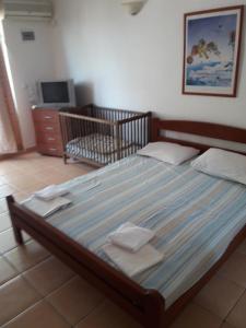 a large bed in a bedroom with a crib at Apartments Vretenicic in Bar