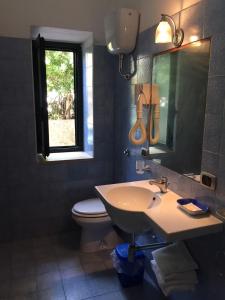 チッタデッラ・デル・カーポにあるB&B Villa Gubitosiのバスルーム(洗面台、トイレ、鏡付)