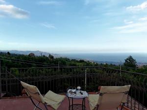 a table and chairs on a balcony with a view at Antica Dimora Benanti in Milo
