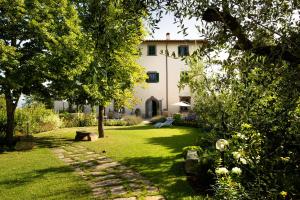 a garden with a house in the background at Roveta Apartment in Scandicci