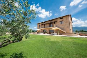 een extern uitzicht op een gebouw met een groene tuin bij Assisium Agriturismo in Assisi