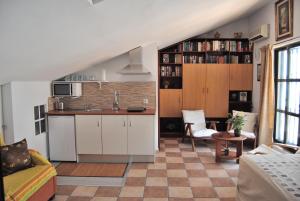 a kitchen with white cabinets and a living room at El Rincon de Isabel in Málaga