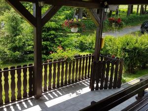 a porch with a wooden railing and flowers at House Petra in Rakovica