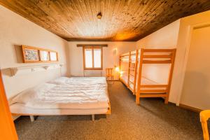 um quarto com uma cama, um beliche e uma escada em Sportchalet Mürren em Mürren