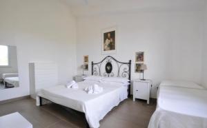 ノート・マリーナにあるVENDICARI Casa Vacanza a Noto Eloro Vendicariの白いベッドルーム(ベッド2台、鏡付)