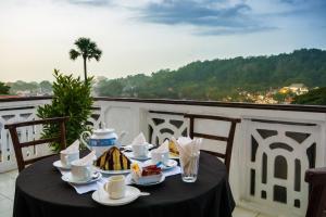 a table with a black table cloth on a balcony at Ceyloni Lake Residency in Kandy