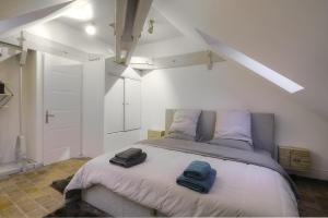 a bedroom with a bed with two towels on it at Academy's Loft in Dijon