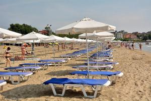 a bunch of chairs and umbrellas on a beach at Apartment Izabela in Primorsko