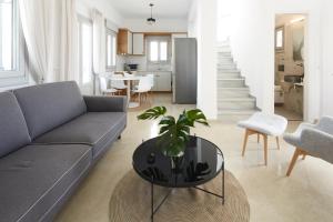 een woonkamer met een bank en een tafel bij Tramonto Private Villa in Monolithos