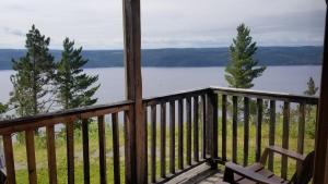 a porch with a bench and a view of a lake at Auberge Cap au Leste in Sainte-Rose-du-Nord