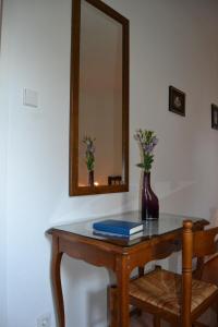einen Tisch mit einem Spiegel und eine Vase mit Blumen darauf in der Unterkunft Hofreit am Bierkeller in Kehl am Rhein