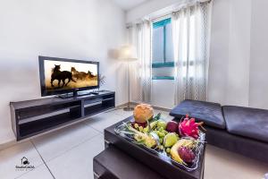 a living room with a television and a table with fruit at Family Vacation by Lake Kinneret in Tiberias +13 photos