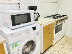 cocina con lavadora y microondas en LLOTJA - Apartamento en la playa y el centro de Roses, en Roses