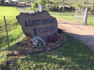 a sign in a flower bed in a yard at Agriturismo Cugumia in Thiesi