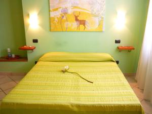 a bedroom with a bed with a yellow blanket at Antica Corte in Lucca