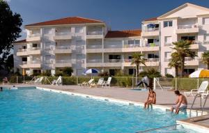 een gezin dat speelt in een zwembad in een hotel bij Residence Thalassa in Les Sables-dʼOlonne