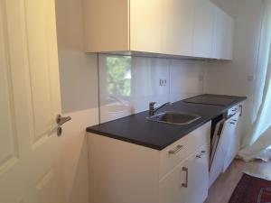 a small kitchen with a sink and a door at GästeHaus in Pinneberg