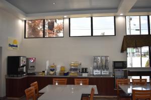 a dining room with tables and chairs and windows at Spark by Hilton Kodak in Kodak