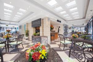 a restaurant with tables and chairs and flowers at Hotel Casa Mahanaim Colferias, Bogotá in Bogotá